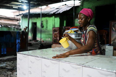 Christiana Joe wiping down the serving counter at the end of the day at the popular Agya Badu 'chop bar' located at Atwemonom, the largest bushmeat market in the city. The restaurant specialises in a...