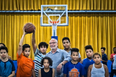 Ben Milow surrounded by Hispanic youths on a backetball court. Milow has set up a youth club in an effort to help Spanish speaking migrants to intergrate into American life.