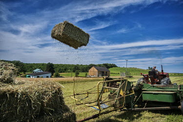 Bob, a farmer making bales of hay on his farm.