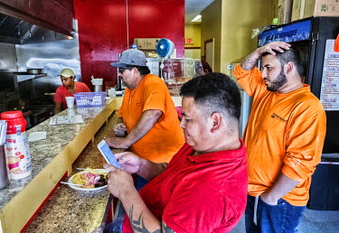 Hispanic customers wait to be served at an empanada snack bar on Wyoming Street.