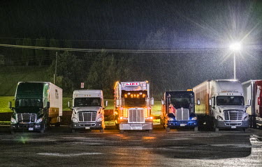 Truckers parked up overnight as heavy rain falls in a car park.