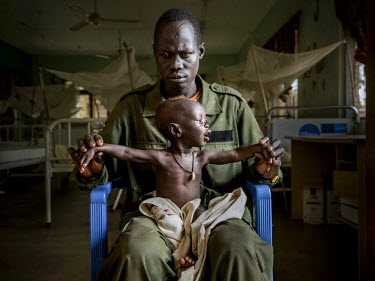 Peter Ksamy Jsiu (31), a soldier from the national army, with his 11 month old son Athian whom he takes care of by himself. They have come to Al Sabbah Children's Hospital in Juba where children suffe...