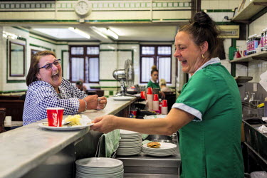 A customer shares a joke in Manze's Pie and Mash shop on Tower Bridge Road.