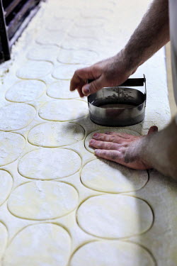 A worker cuts out pastry pie cases at Maureen's Pie and Mash shop.