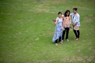 Three young women taking a selfie in a park in Kolkata.
