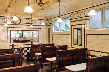 The interior (including the painted tin tiles on the ceiling) of Manze's Eel, Pie and Mash shop in Walthamstow, East London, UK Although the shop still trades under the original Manze name, it is now...