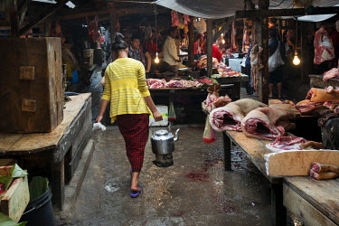 A woman selling chai (tea) in the meat market.