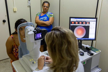 Roseane Rezende (16), watched over by her mother Maria da Conceico Rezende, has her retina examined by doctor Tessa Mattos. Roseane was diagnosed with type 1 diabetes when she was six years old and ha...
