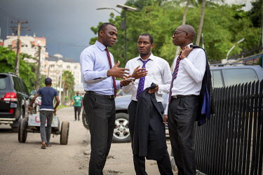 Kom Abasi (centre), an IT specialist working for a bank in the city, chats with colleagues during his lunch break in the city centre on Victoria Island.