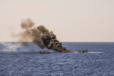 In a final act, after rescuing its occupants, Spanish marines set fire to the flimsy craft that was carrying the migrants across the Mediterranean Sea.