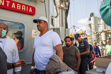 Two men who have been identified as being of 'special interest' are disembarked from the Spanish navy vessel Cantabria, which is operating a migrant's resucue mission in the Mediterranean Sea, accompa...