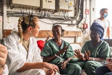 A member of the Spanish military, on the Spanish navy vessel the Cantabria, talks with two Nigerian women who were rescued from a boat carrying migrants on the dangerous crossing of the Mediterranean...