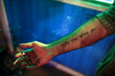Shayan, an Iranian-American lawyer who helps refugees resettle in the United States, shows off the tattoos on his arm that read: 'peace' in Farsi, Hebrew, Arabic and Hindi.