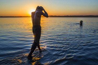 At sunset, people bathe in the Irrawaddy River.