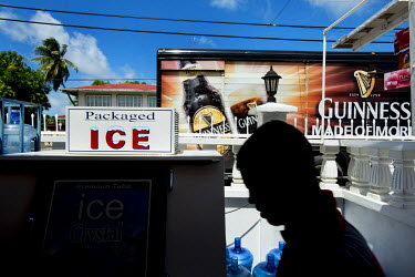 A truck advertising Guinness beer parked outside a shop selling bottled water and ice, on the coastal road between Georgetown and New Amsterdam.