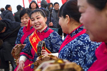 A group of women perform at the Ma Jie folk festival. For centuries farmers in Henan have gathered during Chinese New Year in the region's wheat fields to listen to bards singing and recounting old ta...