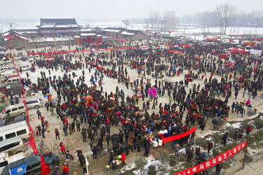 Crowds gather around traditional storytellers at the site of the Ma Jie folk festival.   For centuries farmers in Henan have gathered during Chinese New Year in the region's wheat fields to listen to...
