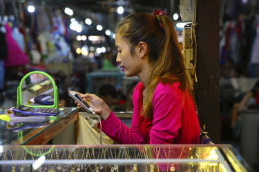 A market stall holder uses a mobile phone.