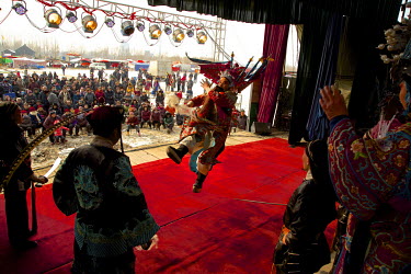 Crowds watch performances on a stage at the Ma Jie folk festival.   For centuries farmers in Henan have gathered during Chinese New Year in the region's wheat fields to listen to bards singing and rec...