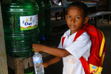 A child fills a bottle with purified drinking water.