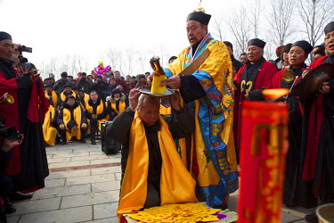 A Taoist priest helps festival organiser Zhang Mantang make an offering the Ma Jie folk festival.   For centuries farmers in Henan have gathered during Chinese New Year in the region's wheat fields to...