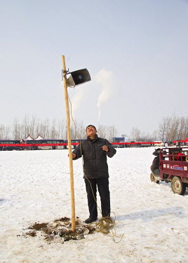 Performer Song Xueyi checks a loud speaker at the Ma Jie folk festival.   For centuries farmers in Henan have gathered during Chinese New Year in the region's wheat fields to listen to bards singing a...
