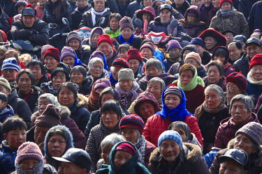 Crowds watch performances at the Ma Jie folk festival. For centuries farmers in Henan have gathered during Chinese New Year in the region's wheat fields to listen to bards singing and recounting old t...
