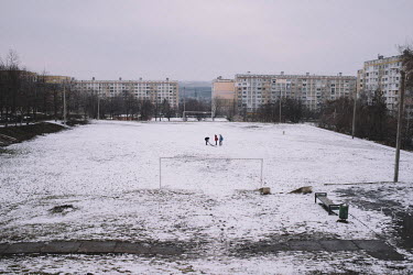 A group of people on a snow covered a football pitch in the Ciocana district.