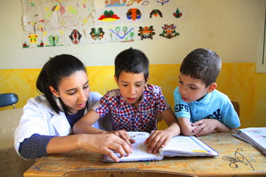 A member of staff helping children read at the Dar Al Atfal Al Wafae (Forsaken children) a home for abandoned children.