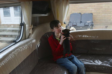 Irish Traveller John Sheridan (11) plays with a puppy in his family's trailer.