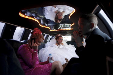 Irish Traveller Shakira Flynn travels by limousine to her First Communion at Our Lady of Good Counsel church in Wickford, Essex, with her brother John and mother Noreen.