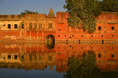 A wing of a palace, used as a girls school, reflected in the Gular Sagar Lake at sunset.