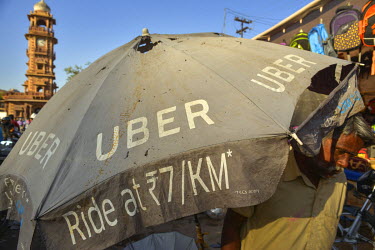 A tattered umbrella advertising the Uber taxi service which is very popular across metropolitan India.