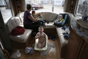 Barbara Sheridan gets her three sons John (bathing, centre), Richard (left) and Dennis (right) dressed in their 'Sunday best' clothes, in their trailer at Dale Farm, an Irish Travellers' site on a for...