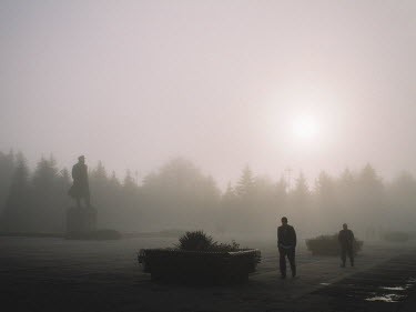 A statue of Lenin in a square in the town centre looms out of the fog.