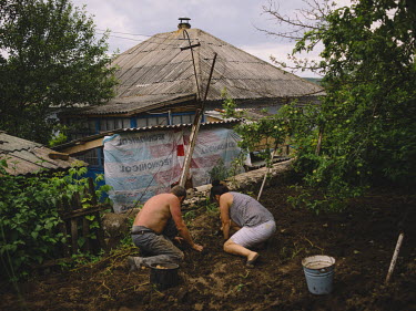 Angela, and her husband Valera, plant potatoes at her grandmother's house.