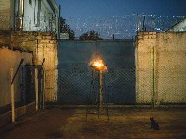A cat sits next to a burning beacon which is part of the stage set for a production of 'Hamlet/Process' inside Penitentiary Nr. 17.