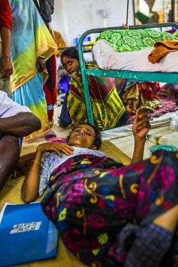 Nasu Khatum, a 40 year old Rohingya refugee, who says she is suffering from a bullet-wound injury to her leg, lies on the floor at the hospital in Cox's Bazar.