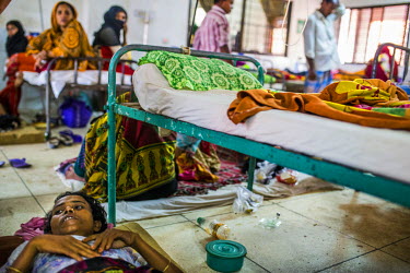 Nasu Khatum, a 40 year old Rohingya refugee, who says she is suffering from a bullet-wound injury to her leg, lies on the floor at the hospital in Cox's Bazar.