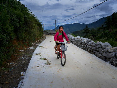 A girl ride her bicycle in Cat Cat Village close to the Chinese border.