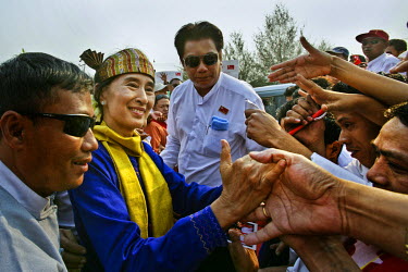 Noble laureate and leader of the National League for Democracy Party, Daw Aung San Suu Kyi, shakes hands with supporters after giving a speech during her campaign for by-elections.