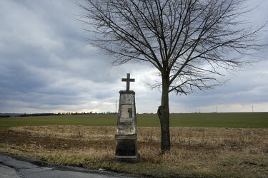 A cross beside a fork in the road in the Central Bohemian Region.