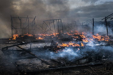 The smoldering remains of shelters destroyed by fire at the so-called 'Jungle' refugee camp. When the authorities moved to close the camp some of the residents decided to set fire to their makeshift s...