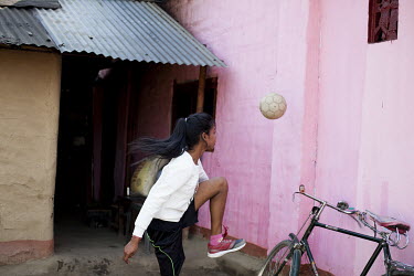 Binita Tanti (15), a member of Smriti Adolescent Girls Group on the Rupai Tea Estate and a keen football player, practices outside her family home.
