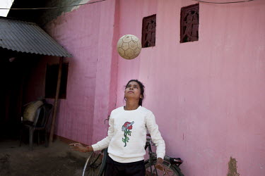 Binita Tanti (15), a member of Smriti Adolescent Girls Group on the Rupai Tea Estate and a keen football player, practices outside her family home.