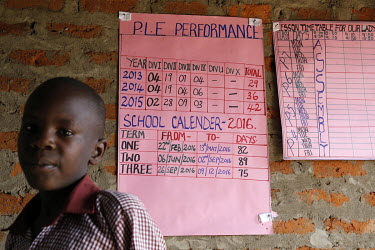 A pupil standing beneath a timetable at a school.