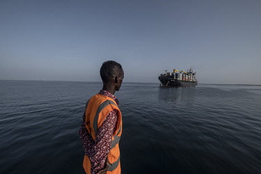 A mooring worker for the Dubai-based DP World looks on as a container vessel, the Sima Pride, approaches the port of Berbera.