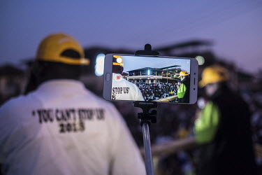 A man takes a video on his phone as supporters of Kandeh Yumkella's National Grand Coalition (NGC) party attend a rally ahead of elections due on 7 March 2018.