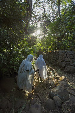 Two women walk towards Betre Mariam church within the forests of Zege.  Forest land surrounding churches have become islands of biodiversity in seas of agriculture, the last remnants of a once-expansi...