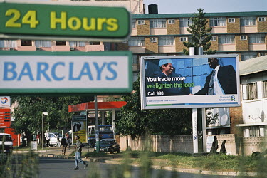 A Barclays bank sign and an advertisement for Standard Chartered bank.